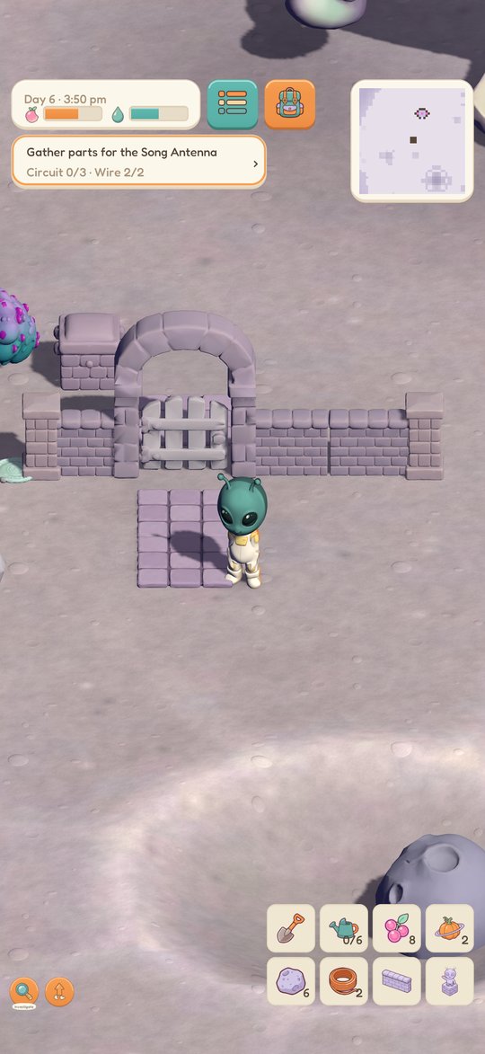 The alien by a brick wall and arched gate on the crater floor.